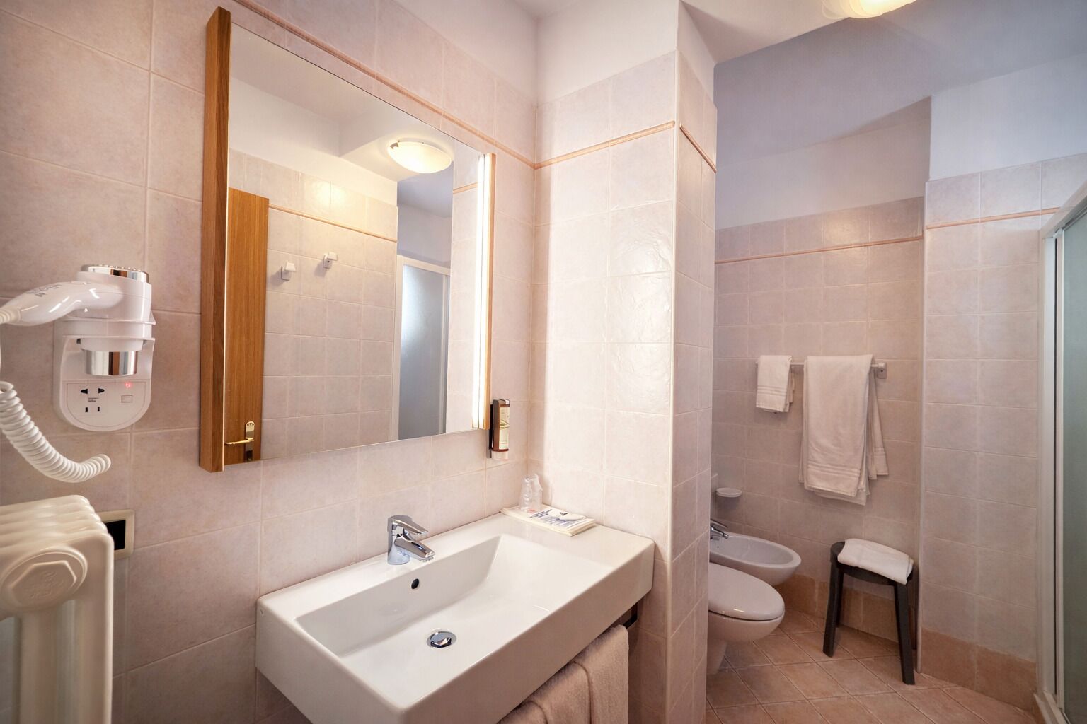 A bathroom with a sink, mirror, and toilet.