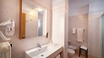 A bathroom with a sink, mirror, and toilet.