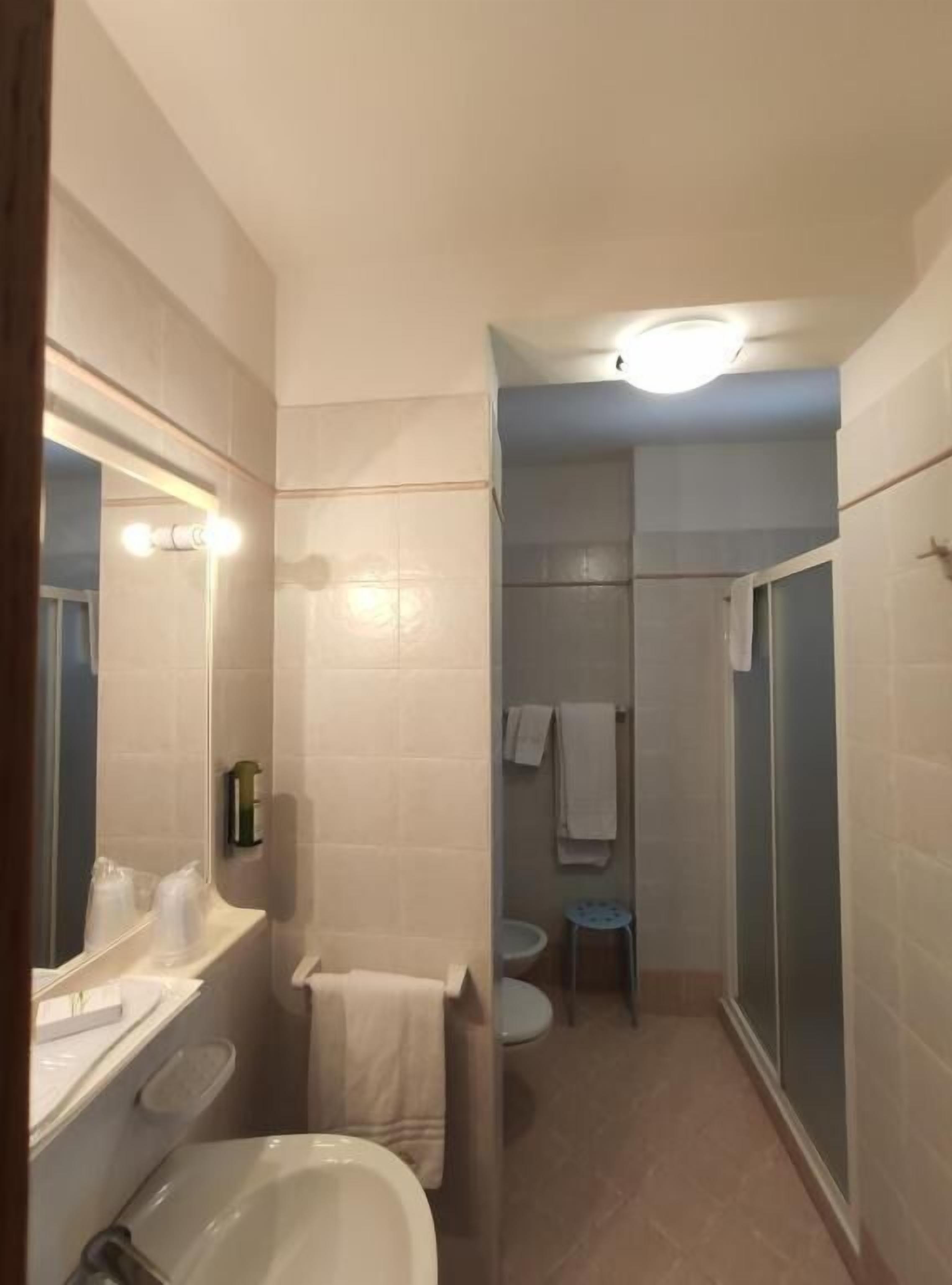Un baño con bañera, lavabo, espejo y zona de ducha.
