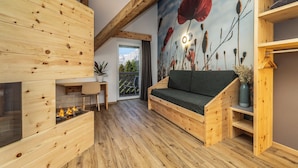 A wooden interior with a sofa, a fireplace, and a mural of poppies. - Pier Hotel (Andalo)
