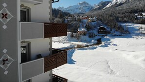 A snow-covered mountain village with chalet-style buildings, a clear sky, and a snowy landscape. - Pier Hotel (Andalo)