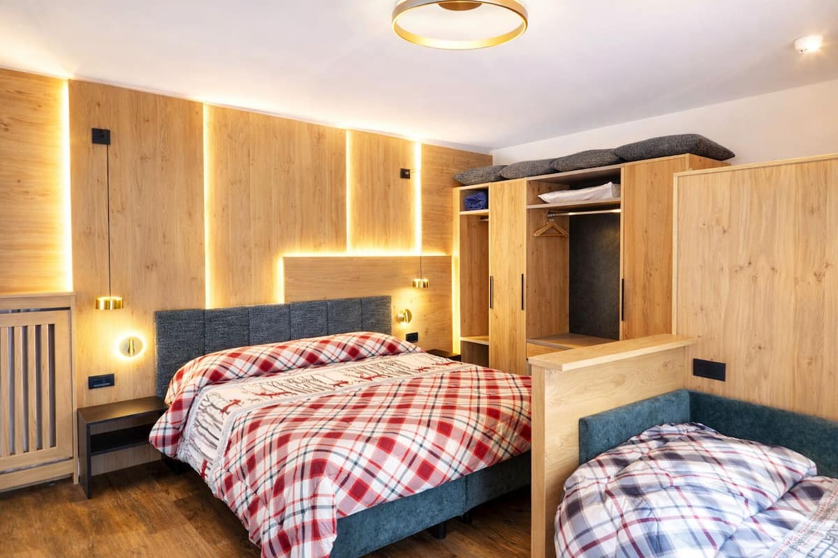 Une chambre à coucher comprenant un lit, des tables de chevet, une armoire et un placard.