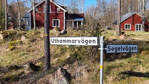A rural setting with a red wooden house labeled 'Uthammervägen' and another labeled 'Segelvägen'.