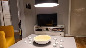 A modern living room with a white table, a bowl, and candles.