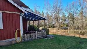 A red building with a covered porch and a wooden fence.