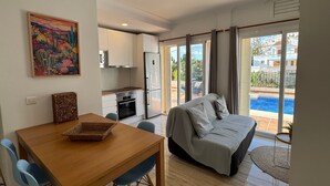 A modern room with a bed, a dining table, and a kitchen area. - Holiday Apartment with Private Pool near the Beach with 2 Terraces and Wi-Fi (Nerja)