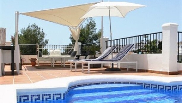 A swimming pool with lounge chairs and a sun umbrella. - Holiday Apartment with Private Pool near the Beach with 2 Terraces and Wi-Fi (Nerja)