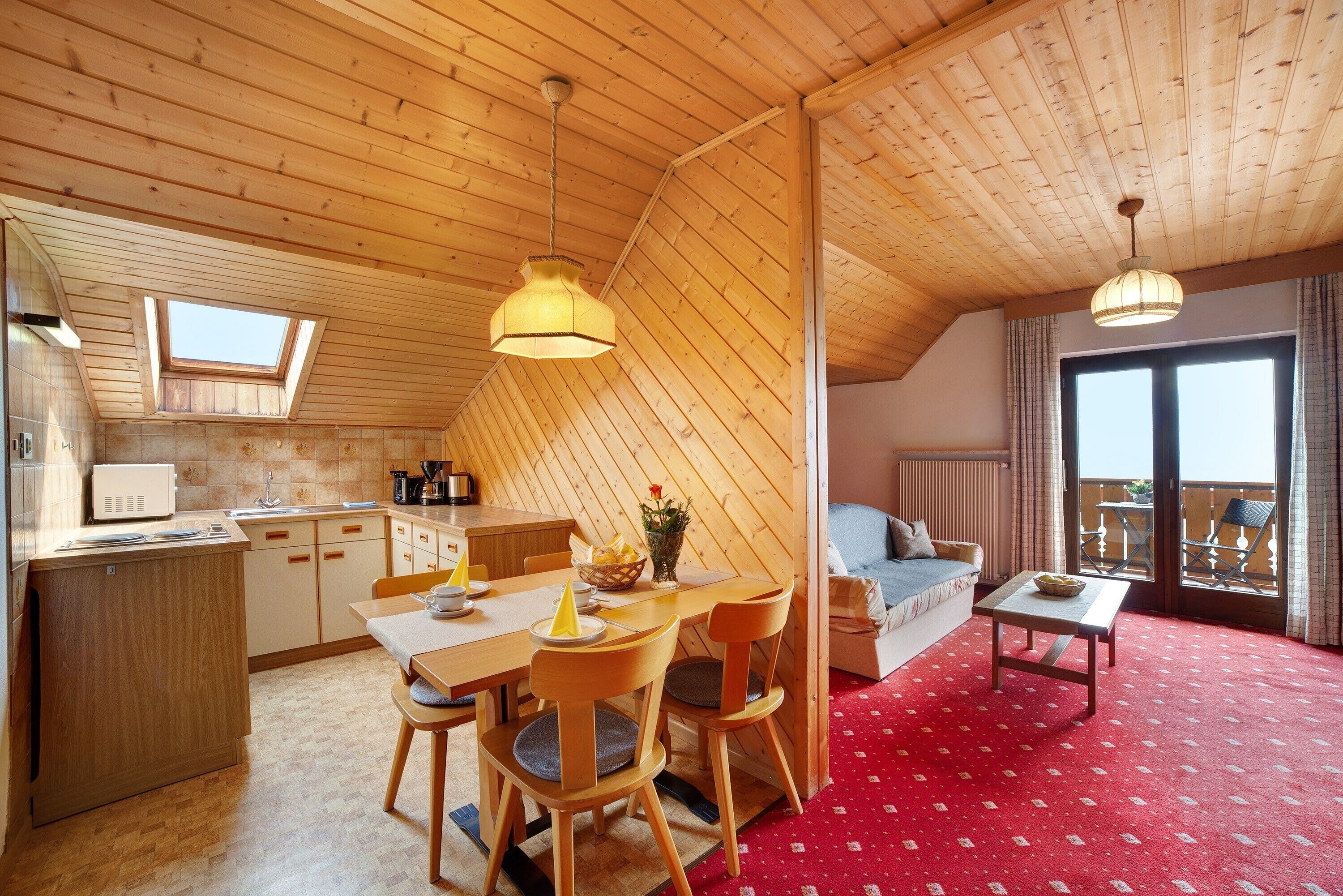 Ein gemütlicher Raum mit Küche, Essbereich und Balkon.