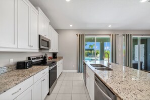 Fridge, microwave, oven, stovetop - Alluring Home with Private Pool and Waterpark & Resort Access near Disney at. (Four Corners)