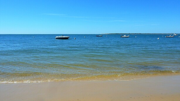A beach with calm waters and several boats. - Central Arcachon - Bright 3* Duplex T3 with Balcony, Parking, and Modern Amenities (Arcachon)
