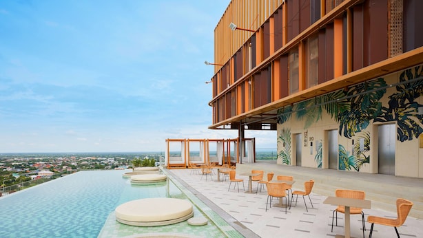 A rooftop infinity pool with outdoor seating and a view of the city. - Centara Korat (Nakhon Ratchasima)