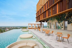A rooftop infinity pool with outdoor seating and a view of the city. - Centara Korat (Nakhon Ratchasima)