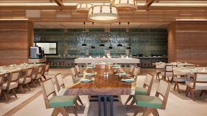 A spacious dining area with a long wooden table, multiple chairs, and hanging wicker chandeliers. - Centara Korat (Nakhon Ratchasima)