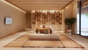 A modern hotel room with a central seating area, a wall-mounted display, and a large window. - Centara Korat (Nakhon Ratchasima)