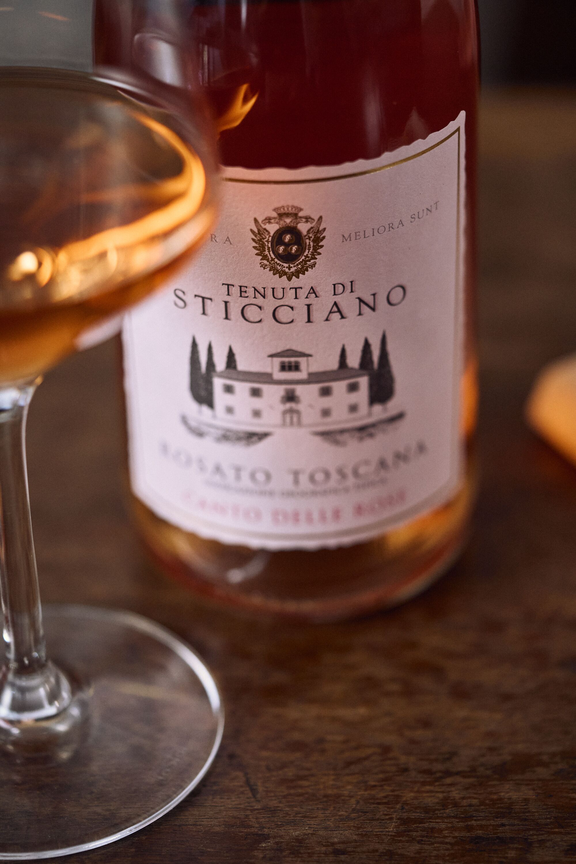 A bottle of Tenuta di Sticciano wine with a label featuring a building and trees.