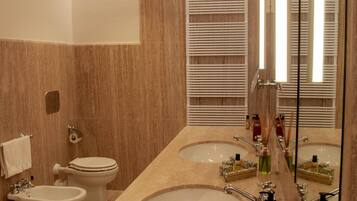 A modern bathroom with two sinks, a toilet, and a bidet.