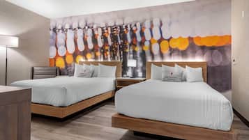 Une chambre d’hôtel avec deux lits, un bureau et une table de chevet. Chaque lit est équipé d’un oreiller muni d’une étiquette.