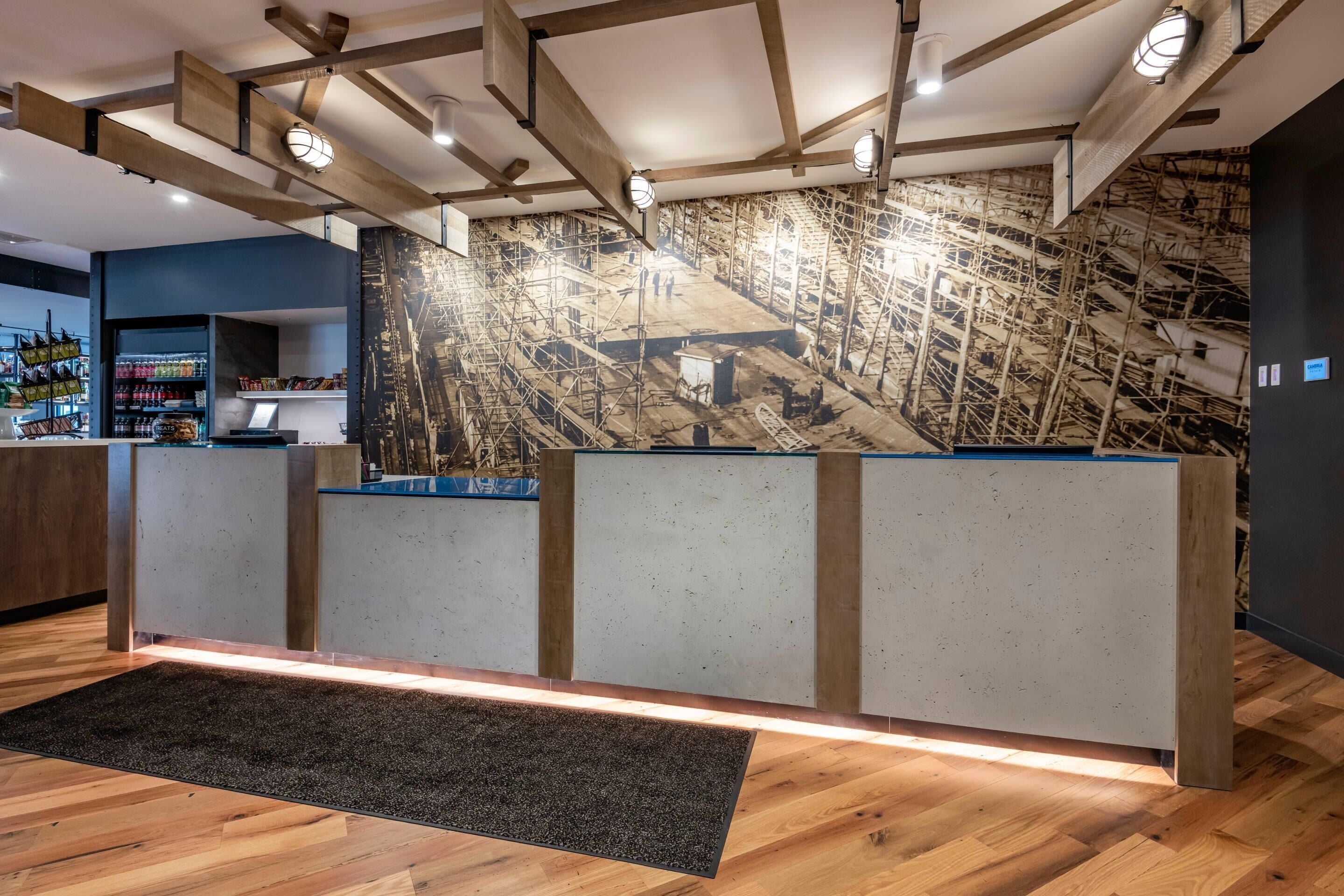 Et moderne receptionsområde med træloft og et stort vægmaleri.