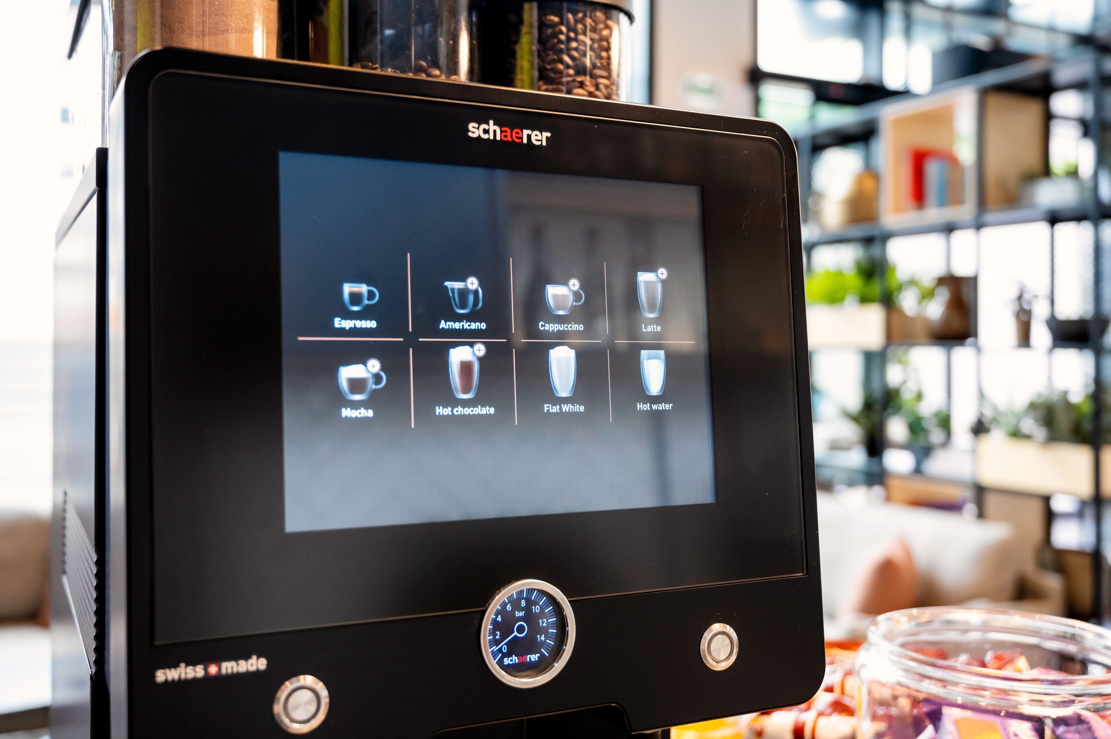 A coffee machine with a digital display showing various coffee options.
