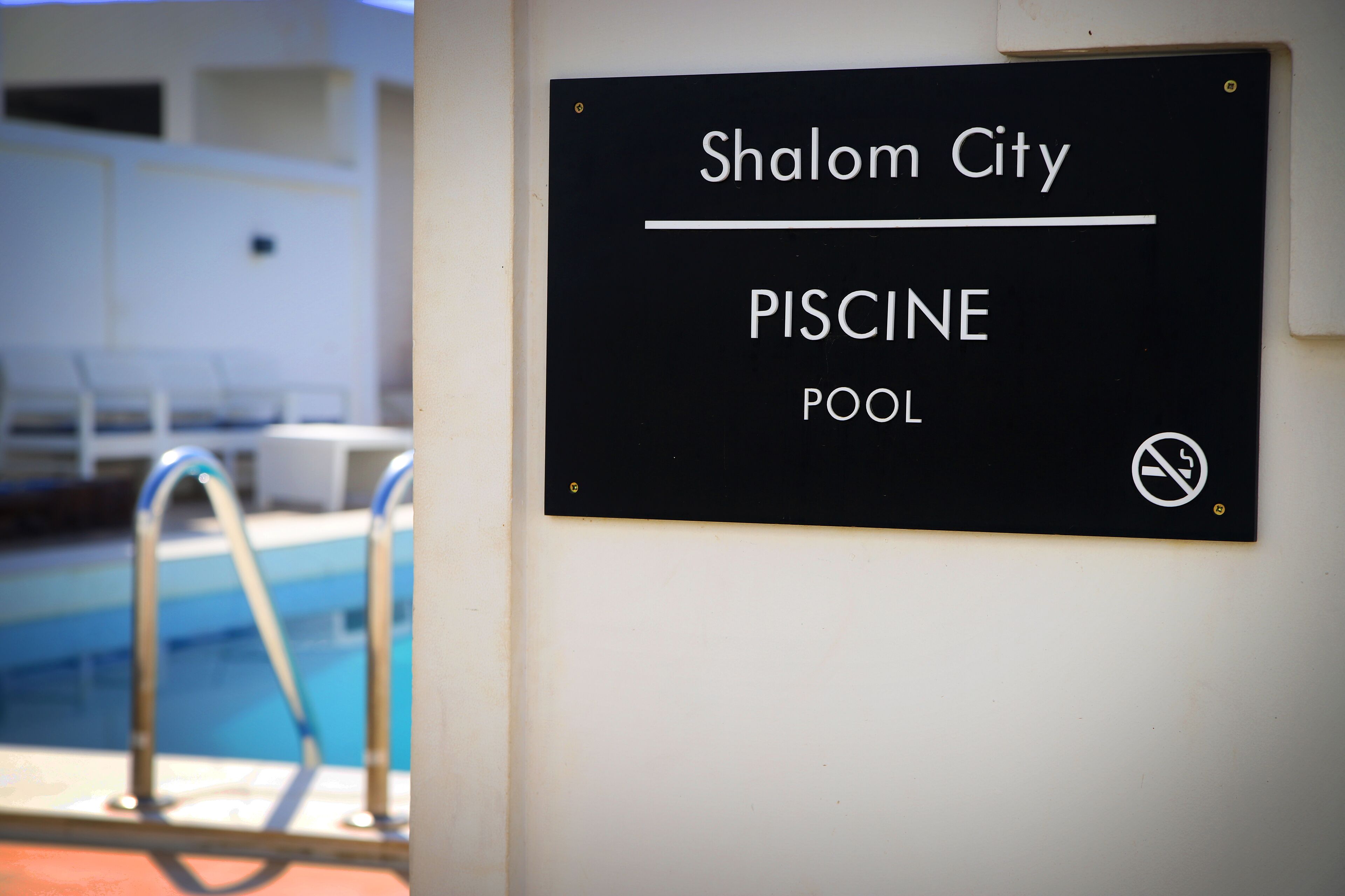 Señalización de una piscina llamada 'Shalom City PISCINE'.