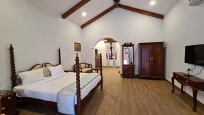 A bedroom with a wooden bed, a wardrobe, a desk, and a television. - Casa Albuquerque (Vagator)