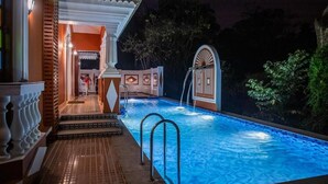 A swimming pool with steps leading to a covered area, surrounded by vegetation. - Casa Albuquerque (Vagator)