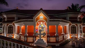 A large, ornate building with a central entrance, multiple balconies, and a staircase leading up to the entrance. - Casa Albuquerque (Vagator)
