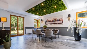 A dining area with a round table, chairs, and a green ceiling. - Serenity Prague Villa with garden jacuzzi (Pruhonice)