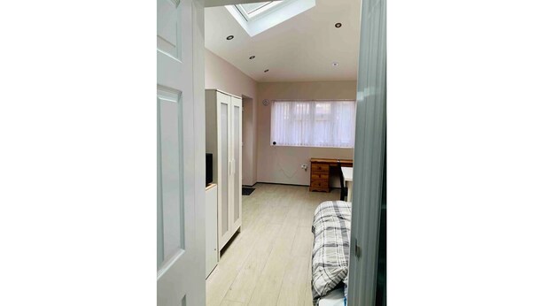 Une chambre à coucher avec un lit, un bureau et une armoire.