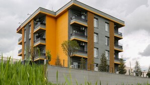 En flereetagers boligbygning med altaner, et fladt tag og en betonfundament.