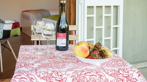 A table with a bottle of wine, two glasses, and a bowl of fruit. - GuestHost - Roomy and tastefully furnished apartment, ideal for families as it accommodates up to 6 people having 2 bedrooms, 2 bathrooms, a balcony and an equipped terrace. The flat is located in a residential context with concierge and internal garden, (Bari)