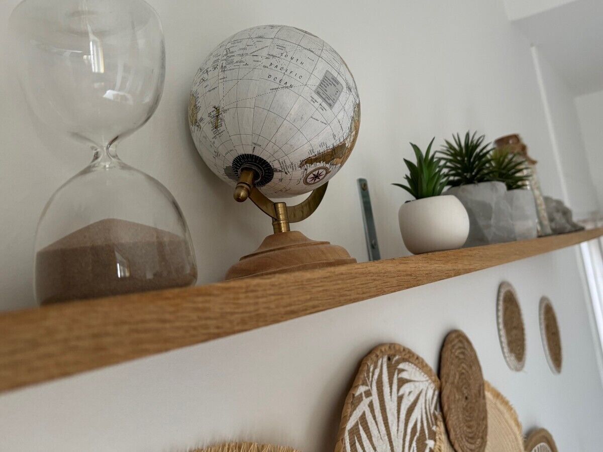 Una estantería con un globo terráqueo, una ampolla de arena y adornos.