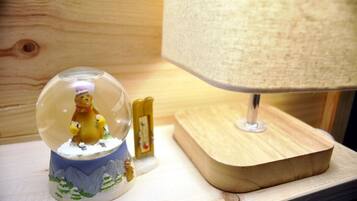 Un globo de nieve con una figura de oso, una lámpara y un bloque de madera sobre una mesa.
