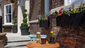 A wooden table with two beer mugs and a potted plant. - The Northallerton Inn - The Inn Collection Group (Northallerton)