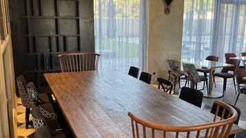 Un espace repas moderne avec une grande table en bois, des chaises à motifs et une tête de taureau décorative accrochée au mur.