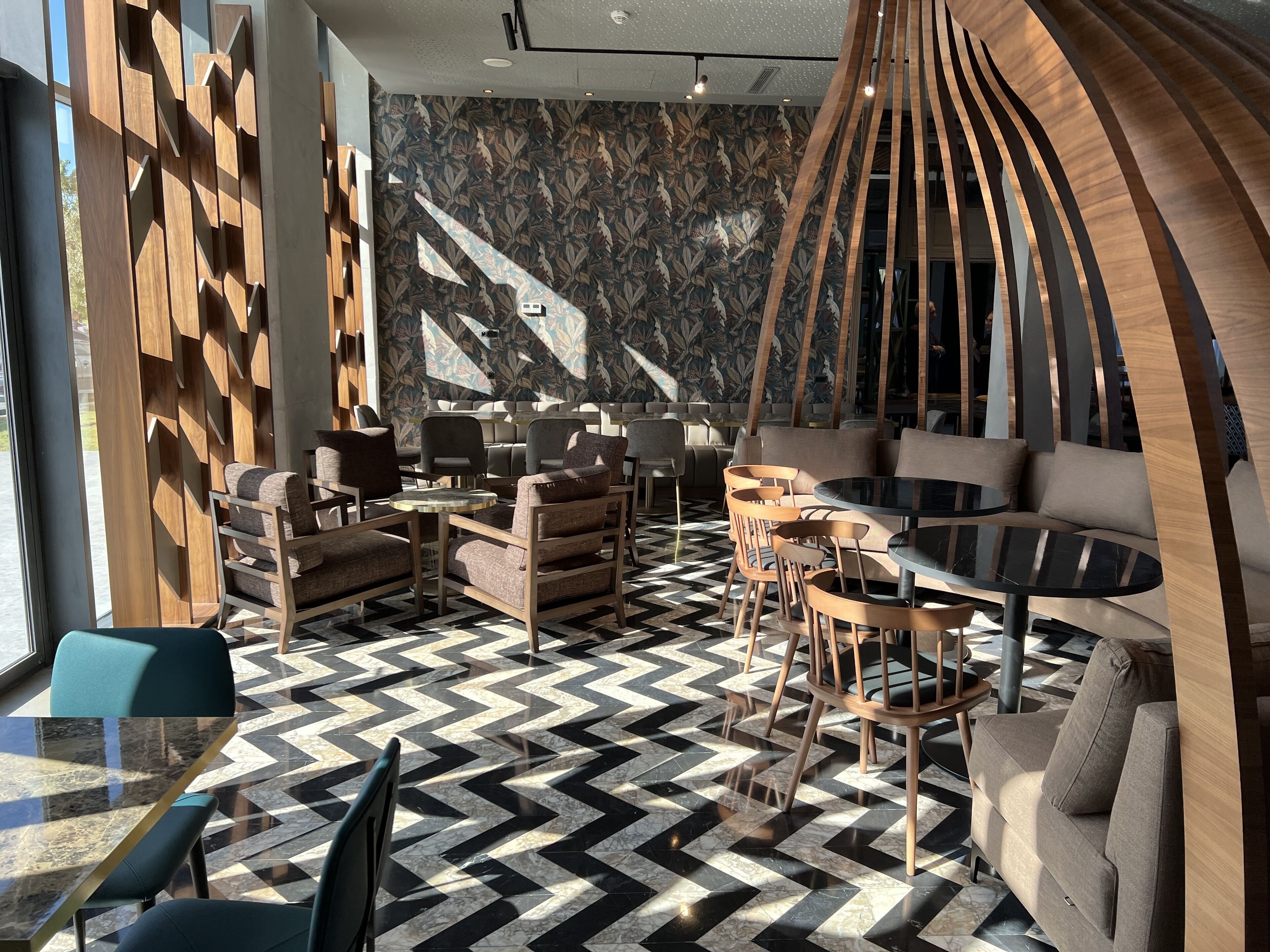 Un intérieur moderne avec un sol à carreaux, des éléments en bois et un mur orné de motifs.