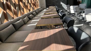 A modern dining area with a long bench and multiple tables.