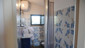 Une salle de bain comprenant un lavabo, des toilettes et un espace douche.