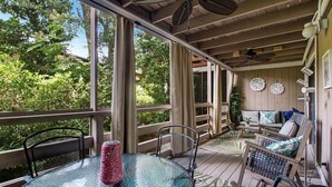 A covered outdoor seating area with a glass table, chairs, and a ceiling fan. - Central Location: Pool, Minutes to Shops & Beach! (Fernandina Beach)