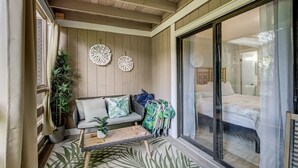 A cozy room with a wooden bench, a sofa, and a bed. There are two decorative wall pieces and a potted plant. - Central Location: Pool, Minutes to Shops & Beach! (Fernandina Beach)
