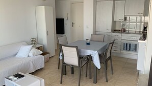 A compact living space with a kitchenette, a dining area, and a sofa.