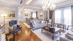 A spacious living room with a grand chandelier, elegant furniture, and a large painting on the wall. - Hilton Garden Inn Samarkand Afrosiyob (Samarkand)