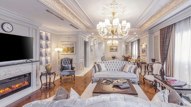 A luxurious living room with a fireplace, a large sofa set, a chandelier, and a television. - Hilton Garden Inn Samarkand Afrosiyob (Samarkand)