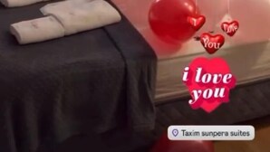 A room with a bed, balloons, and a heart-shaped decoration.