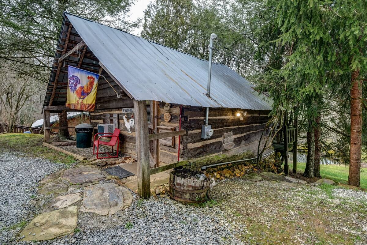 A rustic cabin with a metal roof, wooden walls, and a welcome sign.