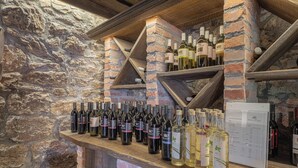 A wine rack with various bottles of wine against a stone wall. - Traditional House Kal Garden & Jacuzzi (Semič)
