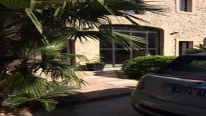 A stone building with a car parked in front.
