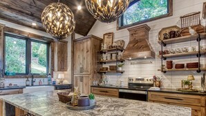 A kitchen with wooden cabinets, granite countertops, and pendant lighting.
