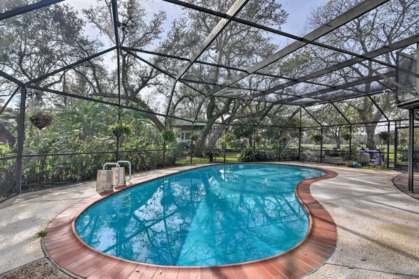 A swimming pool with a wooden deck and metal roof structure. - Lake Access & Pool: Spacious Freeport Home! (Freeport)