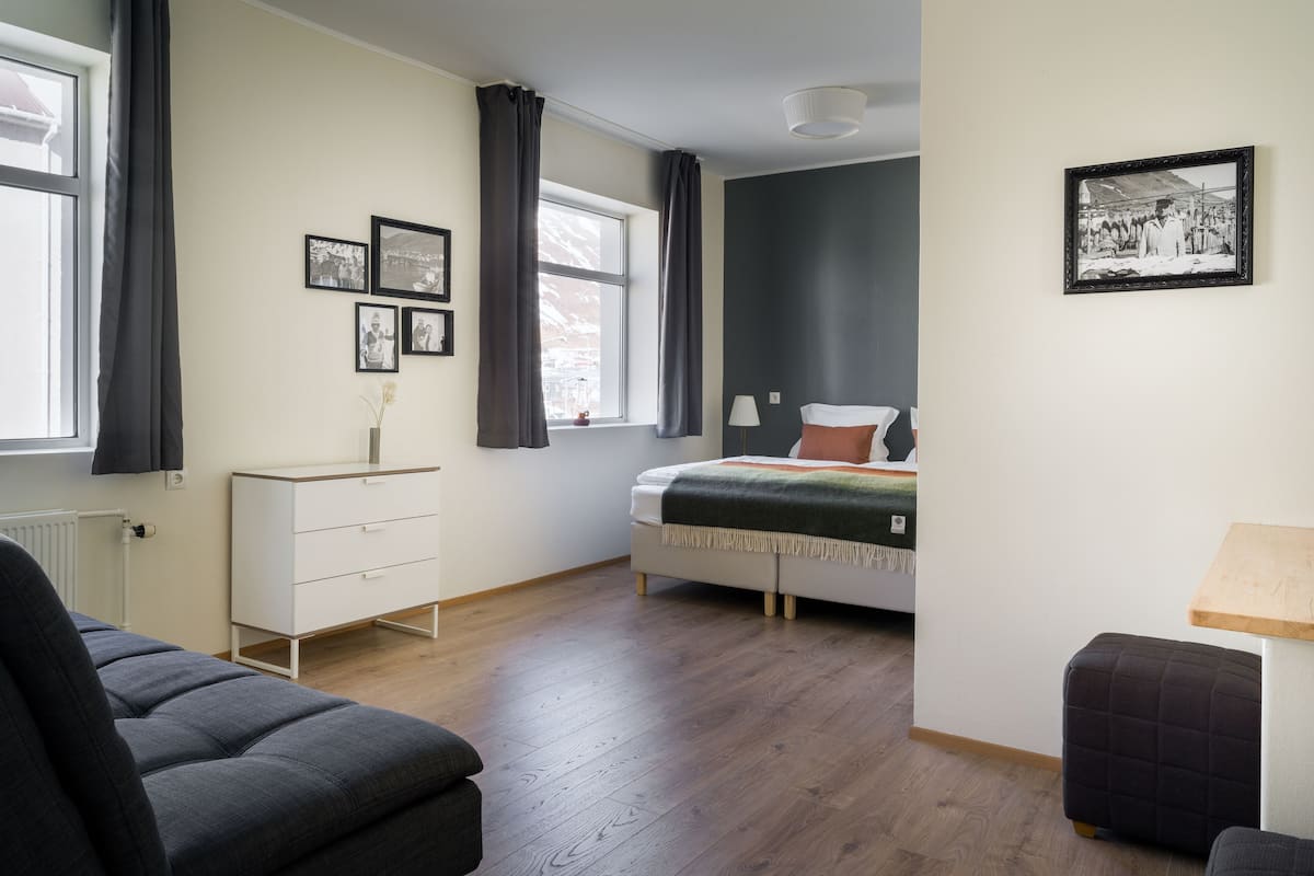 A bedroom with a bed, a dresser, a chair, and a small table.
